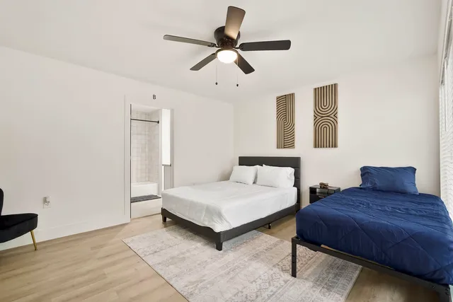 a bedroom with a bed chandelier and a window