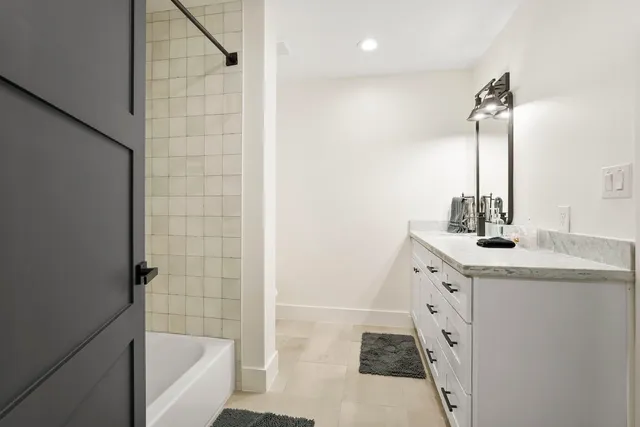 a bathroom with a granite countertop sink a mirror and shower