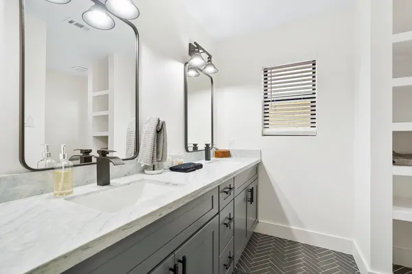 a bathroom with a double vanity sink and a mirror