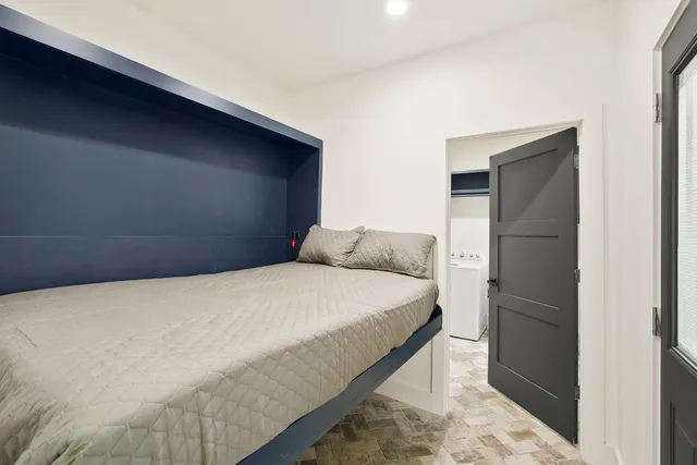 a bedroom with a bed and a refrigerator