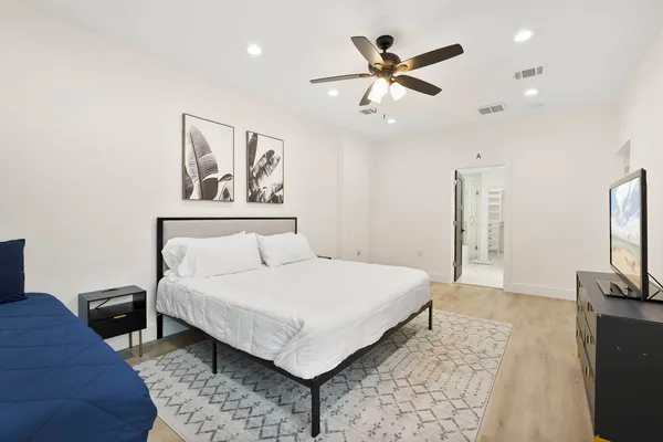 a bedroom with a large bed and a flat screen tv