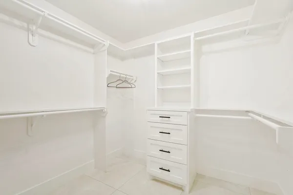 a view of walk in closet with empty racks