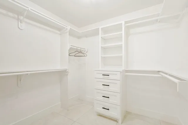 a view of walk in closet with empty racks