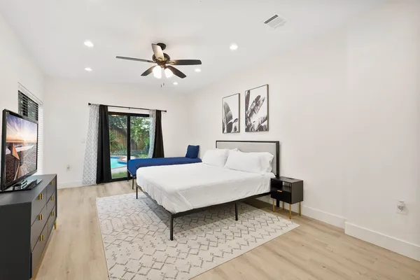 a living room with a bed and a flat screen tv