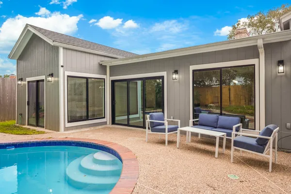 a swimming pool with outdoor seating and yard