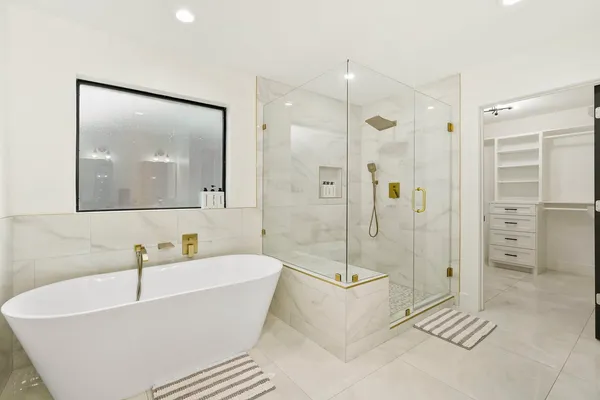 a white bath tub sitting next to a bathroom sink