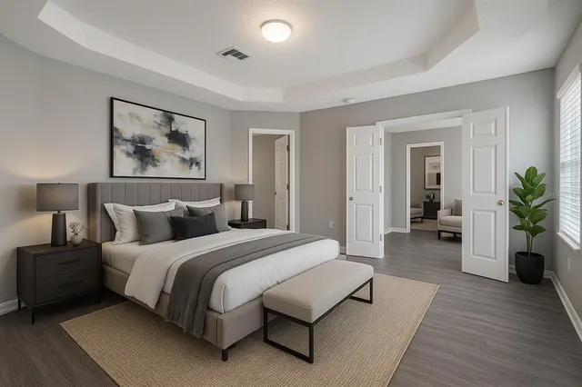 a spacious bedroom with a bed and a potted plant