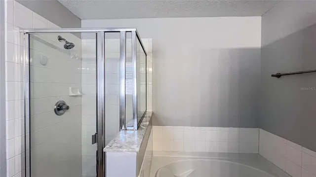 a bathroom with a granite countertop tub sink and toilet