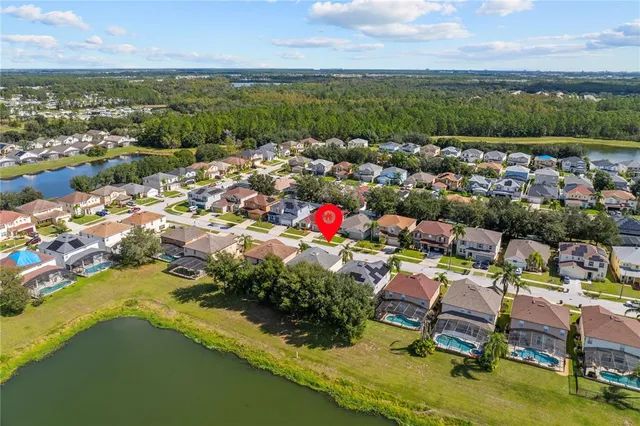 an aerial view of residential houses with outdoor space and lake view
