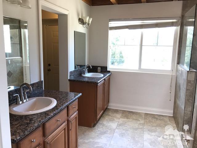 8856 Little Morongo Road Morongo Valley, CA 92256 - Photo 34 of 37 a bathroom with a granite countertop sink and a mirror