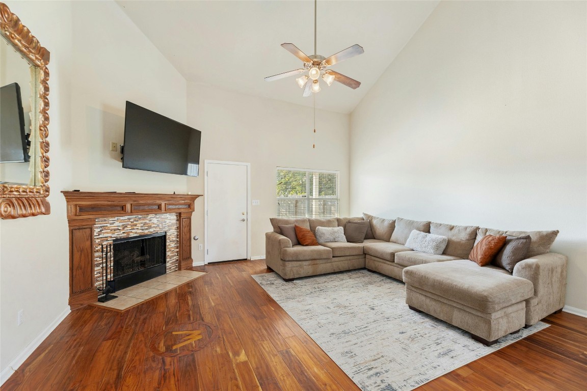 18401 Masi Loop Pflugerville, TX 78660 - Photo 3 of 29 Living room with high vaulted ceiling, a ceiling fan, wood finished floors, and a fireplace