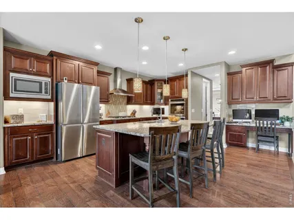 a kitchen with stainless steel appliances granite countertop a sink stove and cabinets