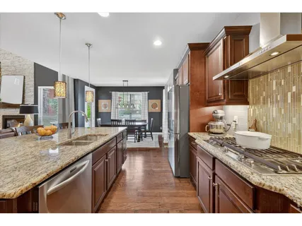 a kitchen with kitchen island granite countertop a stove and a sink