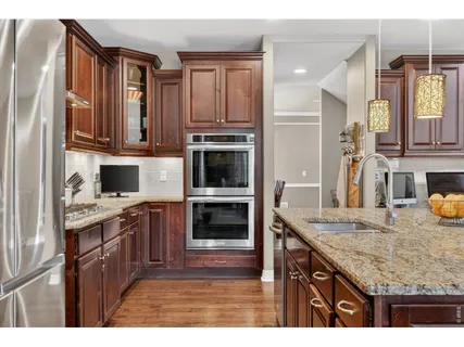 a kitchen with granite countertop wooden floors and wooden cabinets