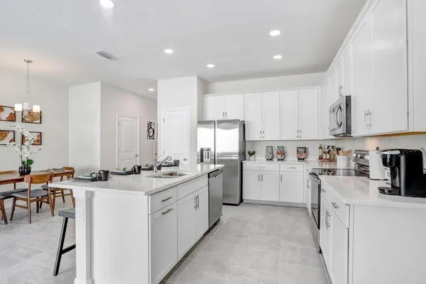a kitchen with appliances a sink a counter top space and cabinets