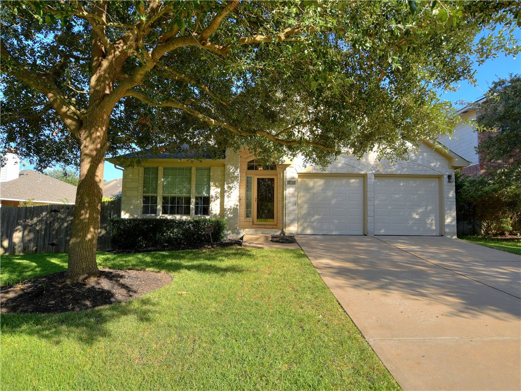 a front view of a house with a yard and a garage
