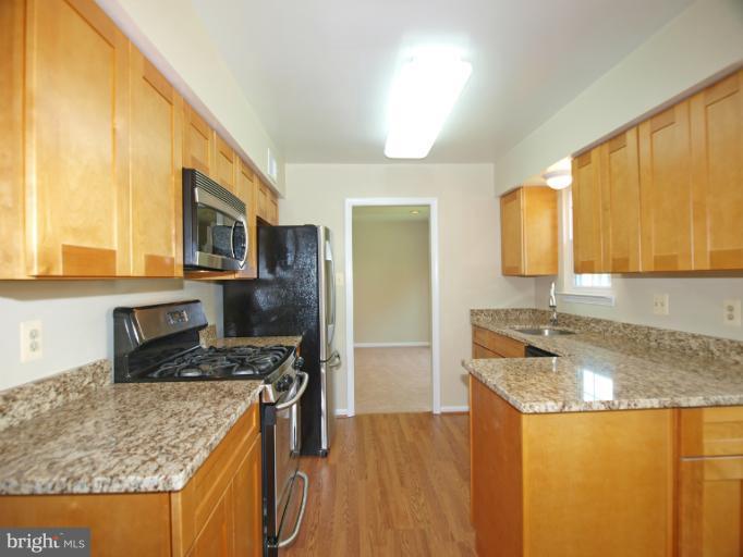 1167 Kersey Road Silver Spring, MD 20902 - Photo 6 of 25 a kitchen with stainless steel appliances granite countertop a sink stove and refrigerator