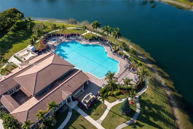 an aerial view of a house with a yard and lake view