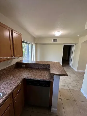a kitchen with granite countertop a sink and a stove top oven