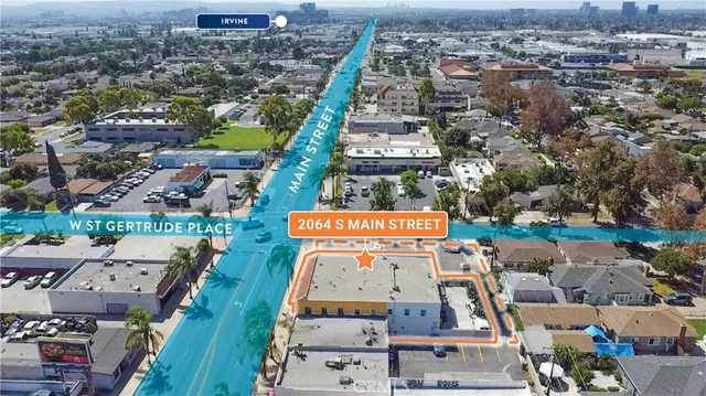 an aerial view of residential houses with outdoor space and parking