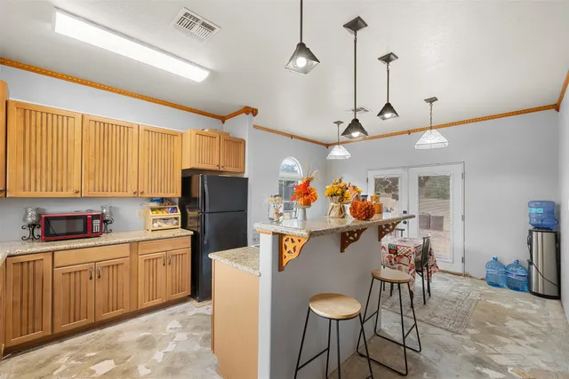 a living room with stainless steel appliances furniture a rug and a dining table