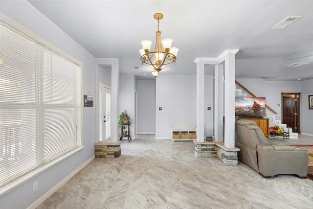 a view of a livingroom with furniture a chandelier and wooden floor