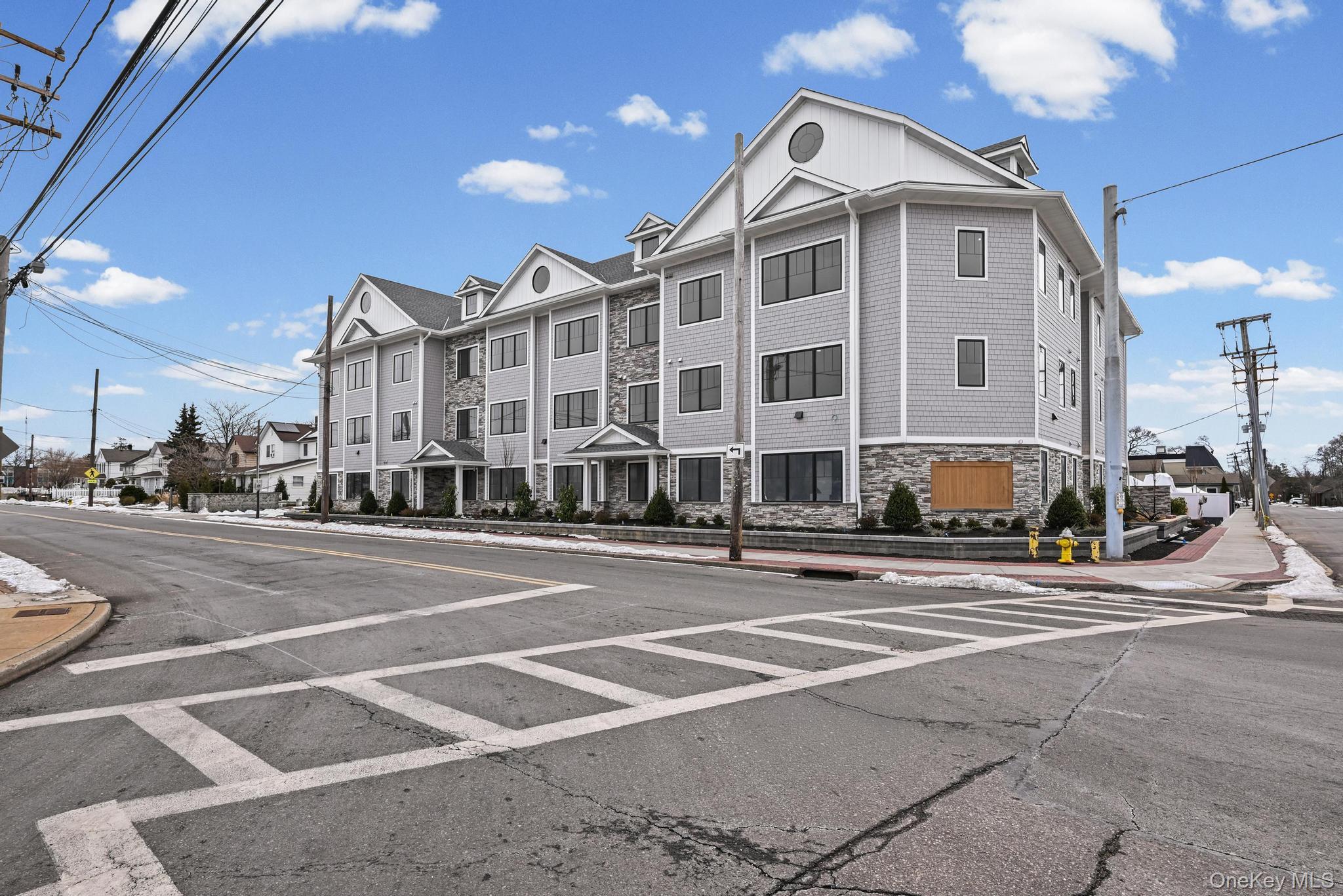 80 Division Street, Unit 3A Patchogue, NY 11772 - Photo 3 of 18 View of asphalt street featuring sidewalks and curbs