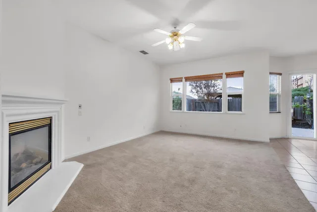 an empty room with windows and fireplace
