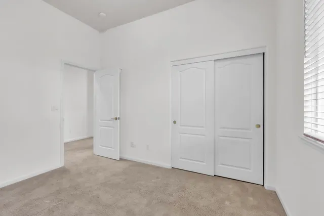 an empty room with windows and closet