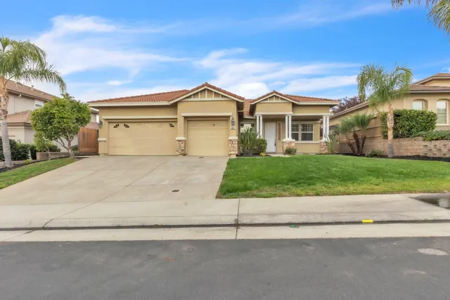 a front view of a house with a yard and garage
