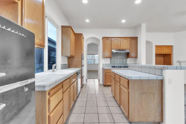 a large kitchen with stainless steel appliances granite countertop a sink and cabinets