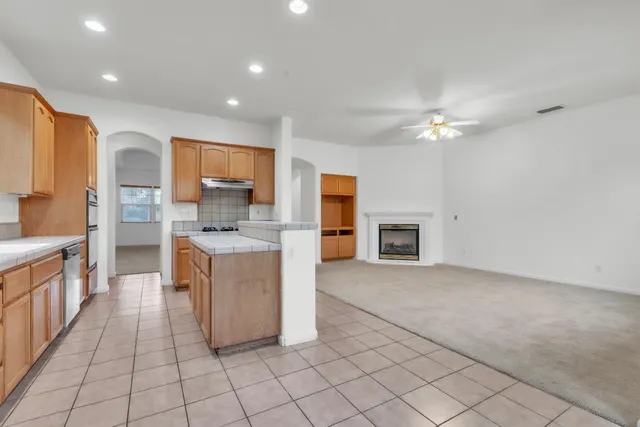 a large white kitchen with a large window and a fireplace