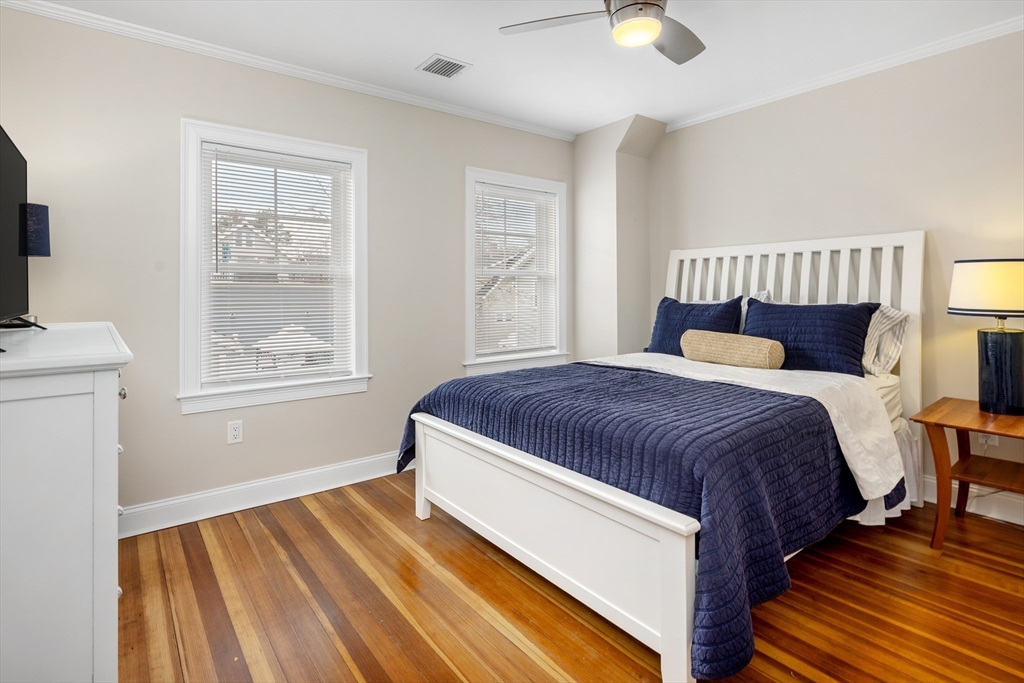 242 Atlantic Avenue, Unit 2 Hull, MA 02045 - Photo 14 of 21 a spacious bedroom with a bed and wooden floor