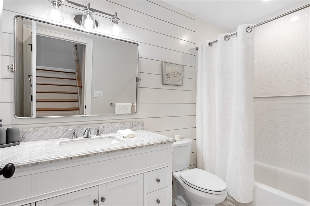 242 Atlantic Avenue, Unit 2 Hull, MA 02045 - Photo 15 of 21 a bathroom with a granite countertop sink toilet and shower