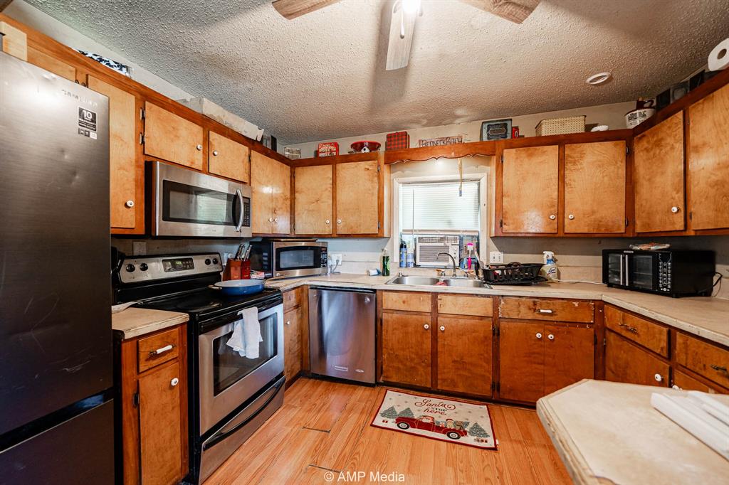 3255 Farm To Market 604 Clyde, TX 79510 - Photo 34 of 36 a kitchen with stainless steel appliances a stove sink microwave and cabinets