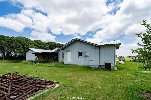 a view of an house with backyard space and a tree