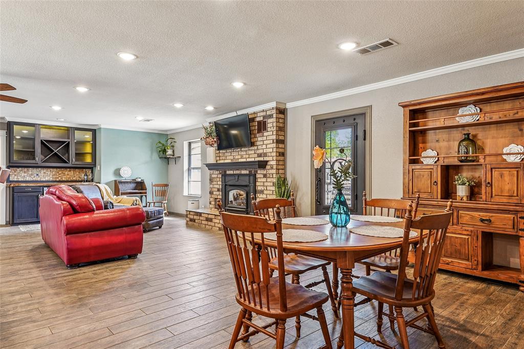 908 North Maple Street Muenster, TX 76252 - Photo 12 of 40 a dining room with furniture wooden floor and a fireplace