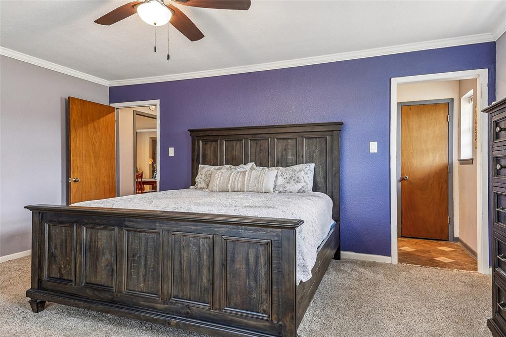 908 North Maple Street Muenster, TX 76252 - Photo 16 of 40 a bedroom with a bed and a chandelier