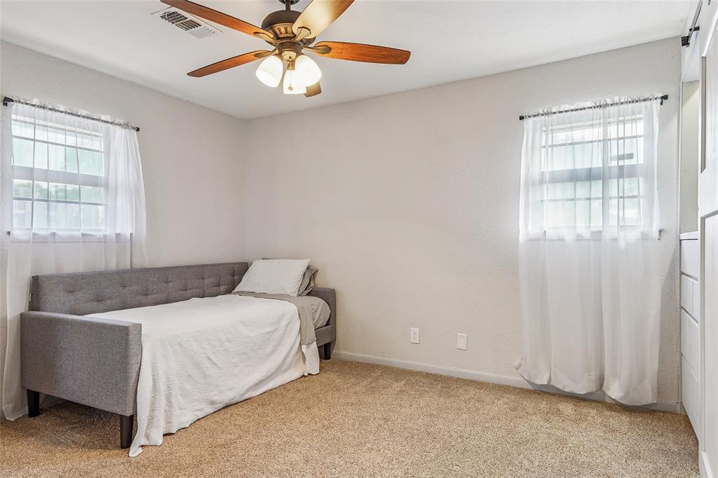 908 North Maple Street Muenster, TX 76252 - Photo 19 of 40 a bedroom with a bed and a chandelier