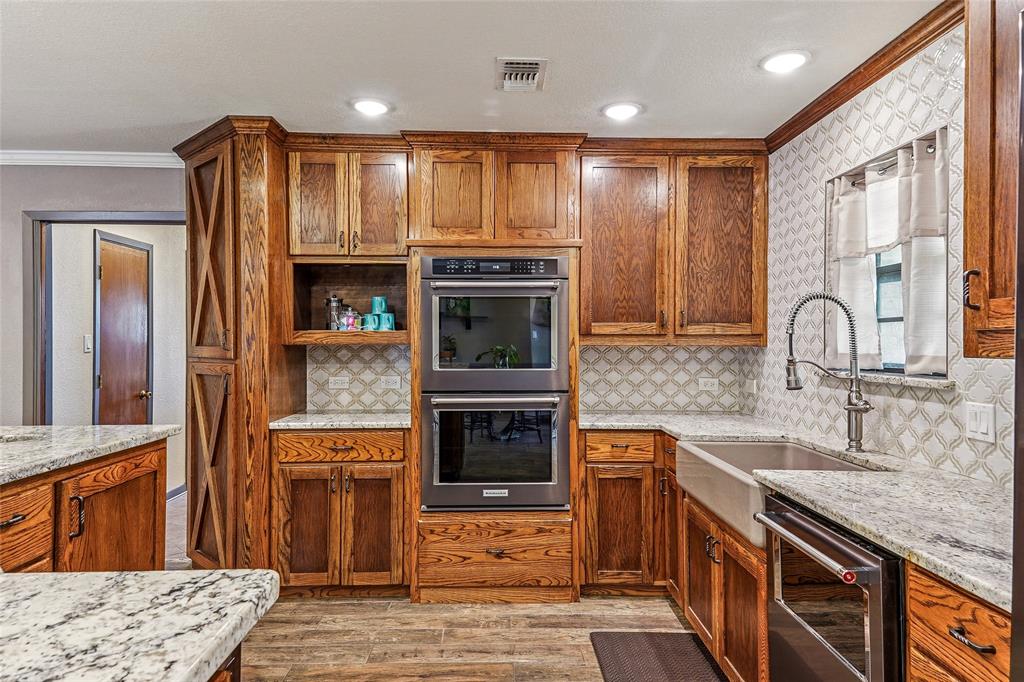 908 North Maple Street Muenster, TX 76252 - Photo 10 of 40 a kitchen with stainless steel appliances granite countertop a stove and cabinets