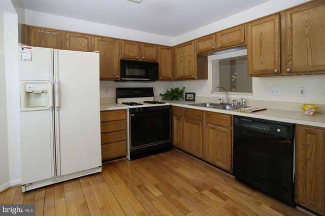 12846 Silvia Loop Woodbridge, VA 22192 - Photo 15 of 30 a kitchen with a sink a stove a refrigerator and cabinets