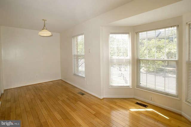 12846 Silvia Loop Woodbridge, VA 22192 - Photo 17 of 30 a view of an empty room with a window and wooden floor