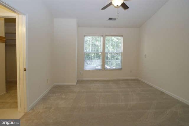 12846 Silvia Loop Woodbridge, VA 22192 - Photo 19 of 30 an empty room with a chandelier fan and windows