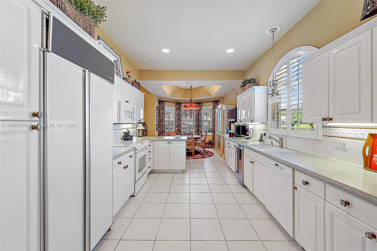 167 North Village Way Jupiter, FL 33458 - Photo 5 of 18 a large white kitchen with lots of appliances a sink and cabinets