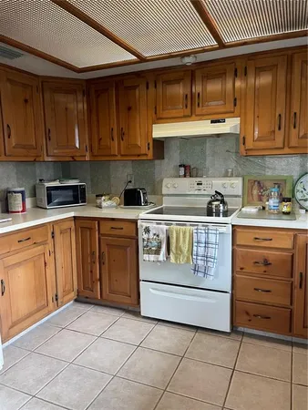 a kitchen with a stove a sink and cabinets