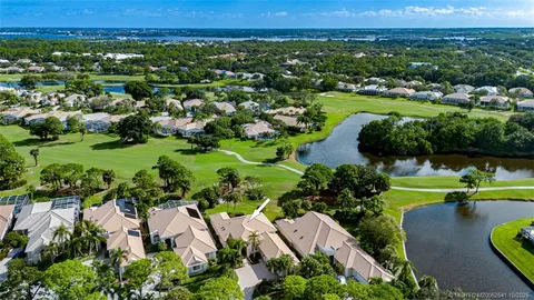 an aerial view of a houses with a yard and lake view