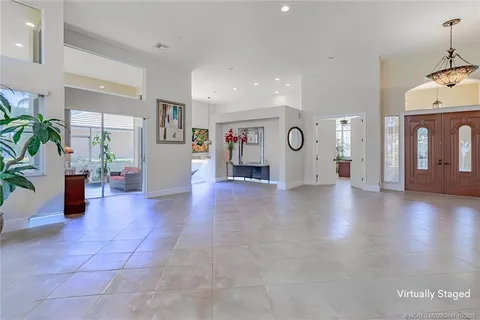 a dining room with furniture a painting and a potted plant