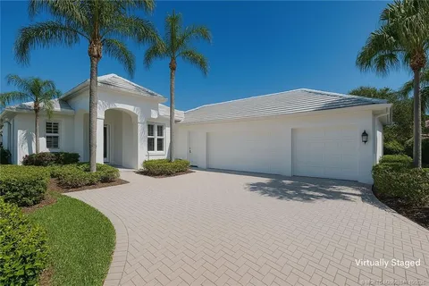 a view of a house with a yard and palm trees