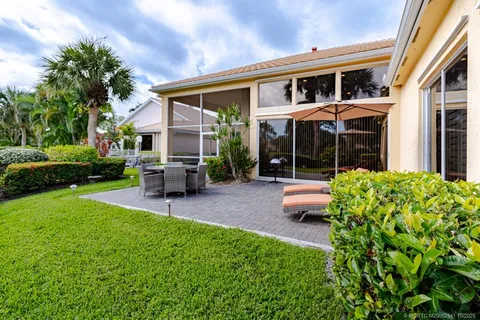 a bathroom with a granite countertop sink a mirror and a glass door shower