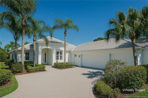 a front view of a house with a yard and potted plants